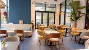 a restaurant with tables and chairs and windows at Modena Resort Spa & Wellness Zlatibor in Zlatibor