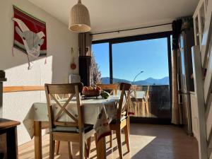 a kitchen with a table and chairs with a view at Chalet Les Angles in Les Angles