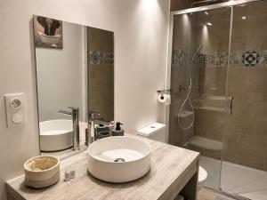 a white bathroom with a sink and a shower at Entre parenthèses - Grand confort et Parking privé in Le Fousseret