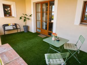 a patio with green grass and a table and chairs at Entre parenthèses - Grand confort et Parking privé in Le Fousseret