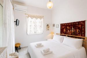 a bedroom with a white bed with two towels on it at Sea View Retreat in Oxílithos