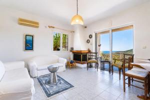 a living room with white furniture and a view of the ocean at Sea View Retreat in Oxílithos