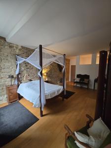 a bedroom with a bed and a stone wall at B&B Le MONSEG 33 in Monségur