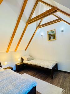 a attic room with two beds and a window at Green Hills - Holiday Home & Events in Kamenica +45 photos