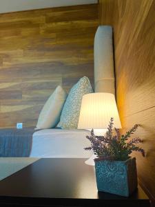 a room with a bed and a table with a lamp at Sunset Yavorov Pomorie in Pomorie