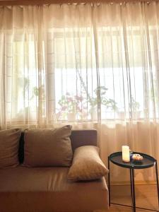 a couch sitting in front of a window with a table at Sunset Yavorov Pomorie in Pomorie