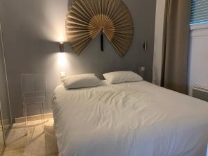 a bedroom with a white bed with a fan on the wall at Appartement Eze bord de mer in Éze