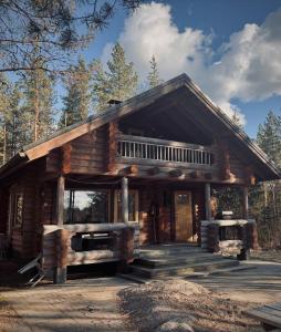 a log cabin in the woods with a porch at Kalliorinteen Mökit Ruskapirtti in Töysä