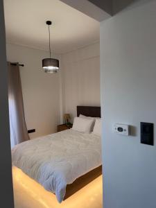 a bedroom with a bed with a white comforter at Urban Nest Corinth in Korinthos