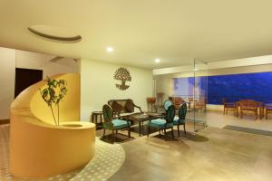 a living room with a table and chairs at Aloha On The Ganges by Leisure Hotels in Rishīkesh