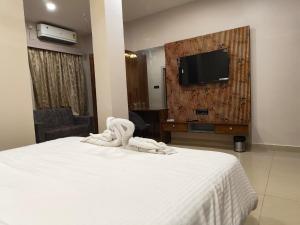 a hotel room with a bed and a flat screen tv at Maa Ambika Royal House in Baripāda