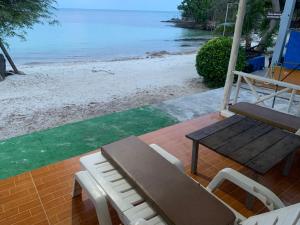 a porch with a swing and a bench and the beach at Koh Samed Lungdam Hutbeach เกาะเสม็ดลุงดำฮัทบีช in Ao Phutsa +100 photos