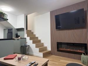 a living room with a fireplace and a tv on a wall at El Rincón de Mateo in Combarro