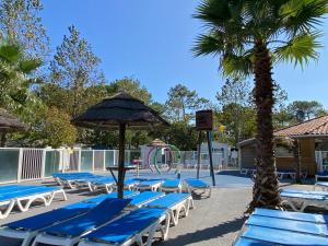 a group of chairs and an umbrella and a playground at Ocean Lodge Messanges in Messanges