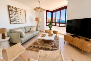 a living room with a couch and a flat screen tv at La Casa del Toro in Corralejo