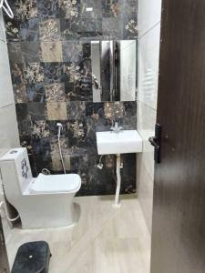 a bathroom with a toilet and a sink at Hotel Empress Grand in Tājganj
