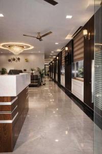 a lobby with a ceiling fan and a long hallway at Hotel Empress Grand in Tājganj