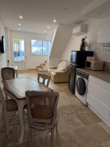 a kitchen and living room with a table and a couch at Les remparts de Sasha in Lapalme