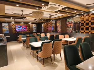 a dining room with tables and chairs and a television at Jakk Residency, ILBS Hospital in New Delhi