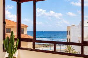 a room with a window looking out at the ocean at La Casa del Toro in Corralejo