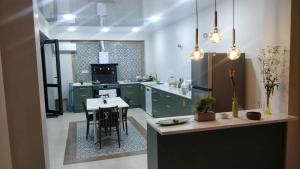 a kitchen with green cabinets and a island with a table at Дом Sand in Ureki