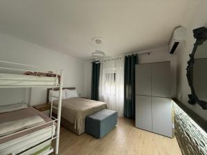 a bedroom with a bed and a bunk bed with a ladder at Canyon River House in Çorovodë