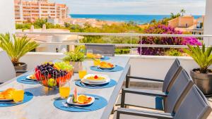 a table with food on a balcony with a view of the ocean at Villa Santa Rosa - Conforto e lazer com piscina e zona de jogos em Armação de Pêra in Armação de Pêra