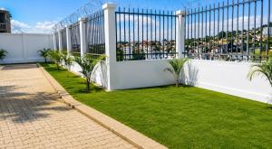 a garden with a white fence and grass at Milestone Villa in Antananarivo