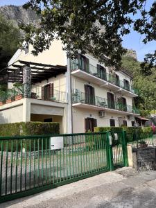 a building with a green fence in front of it at Il Casalino in Maratea