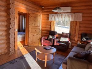 a living room with a couch and chairs and a table at Kalliorinteen Mökit Havupirtti in Töysä