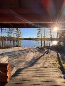 a view of a wooden bridge over a lake at Kalliorinteen Mökit Havupirtti in Töysä +5 photos
