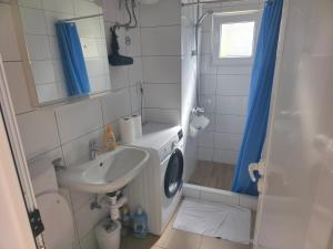 a bathroom with a sink and a washing machine at Apartman deluxe sea in Split