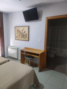 a bedroom with a desk and a television on the wall at Balcones Azules in Cartagena