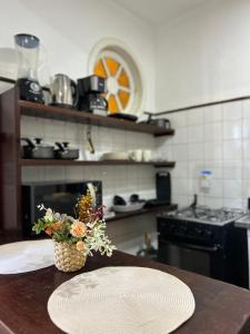 a kitchen with a table with a plate and a vase of flowers at Casa Exclusiva Centro Búzios in Búzios +20 photos