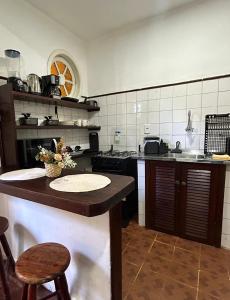 a kitchen with a counter with two chairs in it at Casa Exclusiva Centro Búzios in Búzios