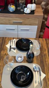 a table with a black plate and utensils on it at Golden Leaf Apartment with Parking in Burghausen