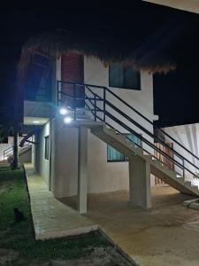 a staircase to a building at night with a light at Miriam Lofts in Bacalar
