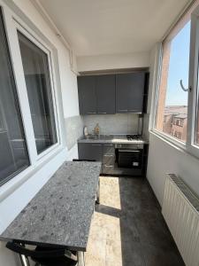 a kitchen with a table and a large window at R&C Relax Apartment 808 in Dudu