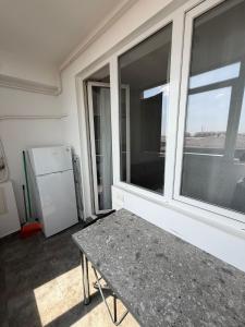 a room with a table and a window and a refrigerator at R&C Relax Apartment 808 in Dudu