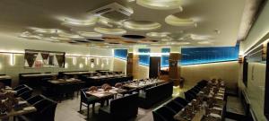 a dining room with tables and chairs and a ceiling at Hotel Decent in Bhāndu