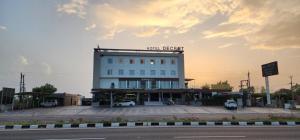 a building with cars parked in a parking lot at Hotel Decent in Bhāndu