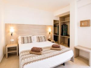 a bedroom with a large white bed with two pillows at Hotel Ses Puntetes in Cala d´Or
