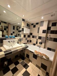 a bathroom with a tub and a sink and a mirror at Hôtel La Riviera Victoria in Yvoire +47 photos