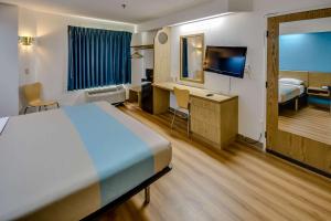 a hotel room with a bed and a desk and a television at Motel 6-Katy, TX - Houston in Katy
