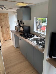 a small kitchen with a stove and a sink at Mobilhomme in Brêmes