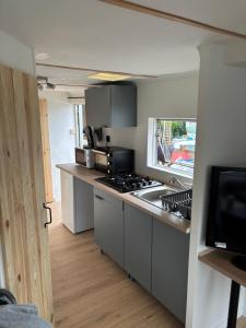 a kitchen with a stove and a counter top at Mobilhomme in Brêmes