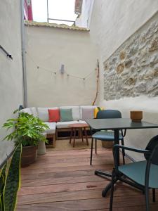 a couch in a room with tables and chairs at Lanabi - Studio Cocon in Salies-de-Béarn