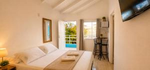 a living room with a white couch and a window at GH Barra da Lagoa in Florianópolis