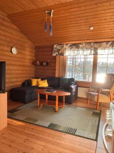 a living room with a couch and a coffee table at Kalliorinteen Mökit Lehtipirtti in Töysä