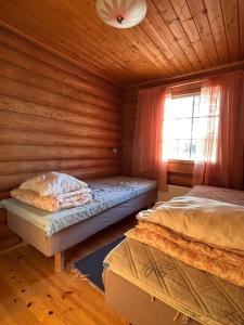 a bedroom with two beds in a wooden cabin at Kalliorinteen Mökit Lehtipirtti in Töysä